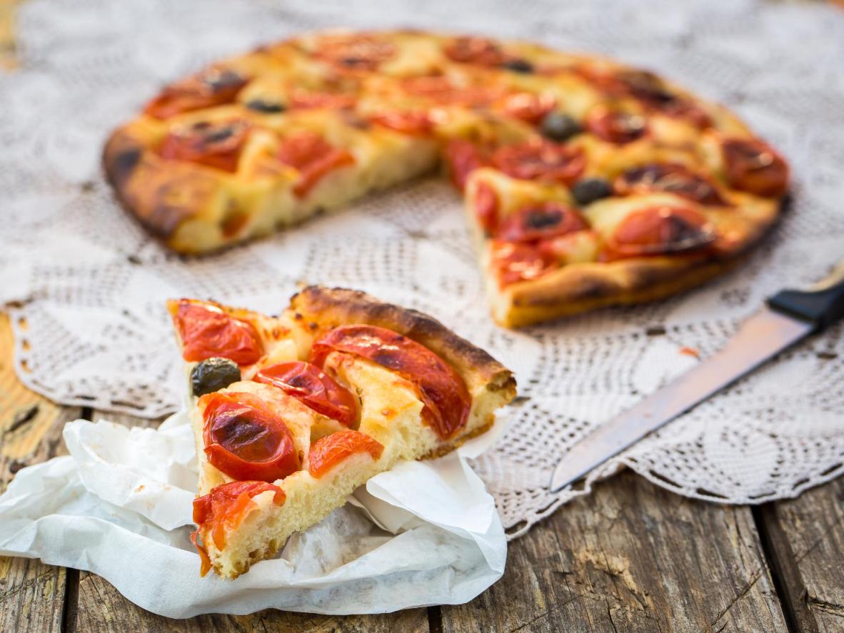 Una tipica focaccia pugliese con pomodori e olive