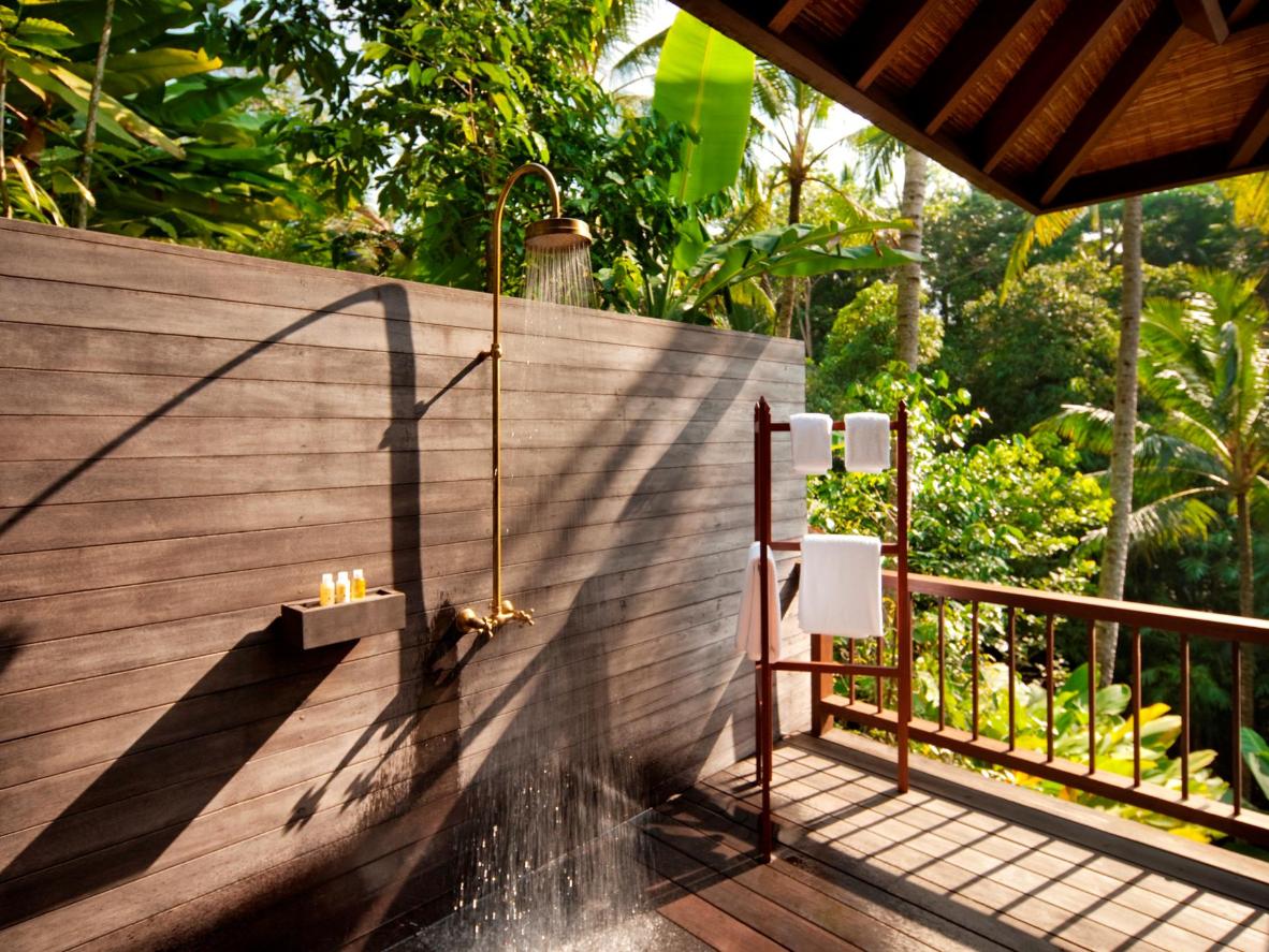 Infinity pool and outdoor showers in lush green surroundings at COMO Shambhala Estate